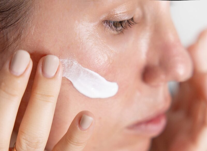 zumiran prikaz devojke koja stavlja kremu na svoje lice